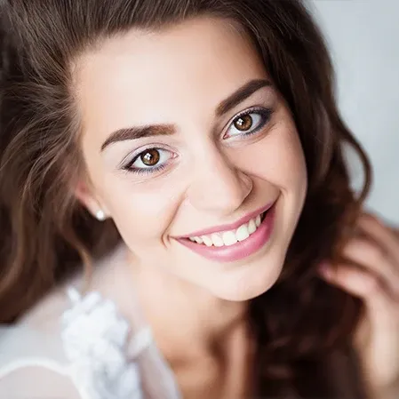 A beautiful young woman smiling and showing off straight, white teeth