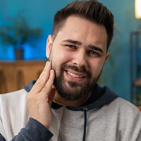 A man with tooth pain holding his jaw