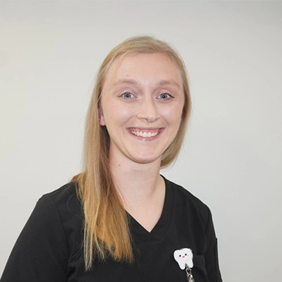 Brianna Hamilton smiling in front of a white wall.