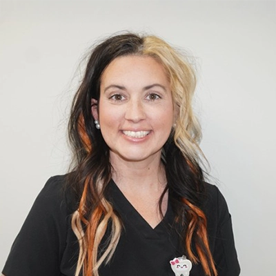 Christine Doyle smiling in front of a white wall.