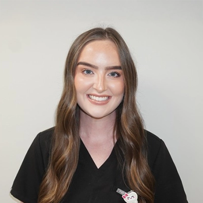 Kirstyn Daulton smiling in front of a white wall.