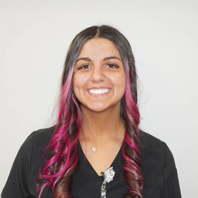 Shandria Esham smiling in front of a white wall.