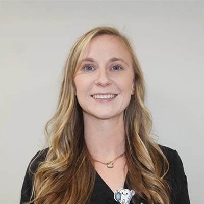 Victoria Gallenstein smiling in front of a white wall.